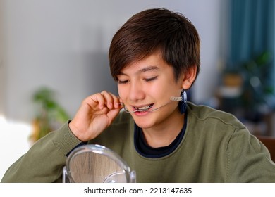 Teenager Boy With Diastema Overbite Teeth Missing Gap Problem Wearing Orthodontic Appliance Treatment Infant Of The Mirror. Dental Braces And Child Tooth Care Concept.