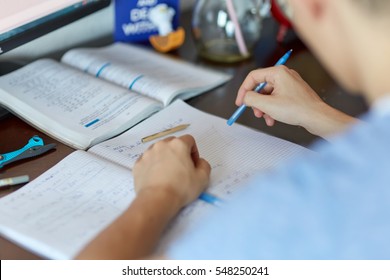 Teenager Boy Doing Homework On His Desk At Home