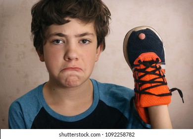 Teenager Boy Frustrated About Hole In His Favourite Trainers Shoes Close Up Portrait