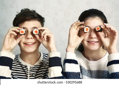 Teenager Boy And Girl With Sushi Japanese Roll Eyes Smiling Close Up Portrait.