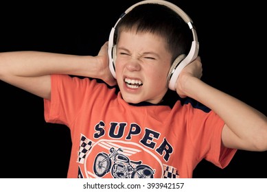 Teenager Boy In Headphones With Loud Music Scared On A Dark Background