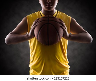 Teenager boy holding a basket ball, Isolated on-a black