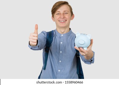 Teenager Boy Holding Piggy Bank  With Thumb Up Signs Over White Background. Financial Education Savings Concept.