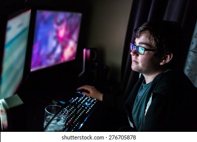 Teenager boy on computer in his room late at night.