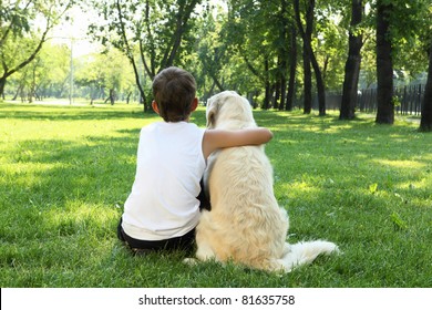 Teenager boy in the park with a golden retriever dog - Powered by Shutterstock