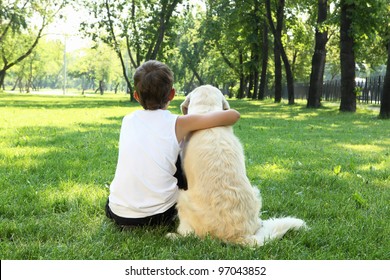 Teenager boy in the park with a golden retriever dog - Powered by Shutterstock