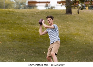 teenager boy playing american football in green park - Powered by Shutterstock