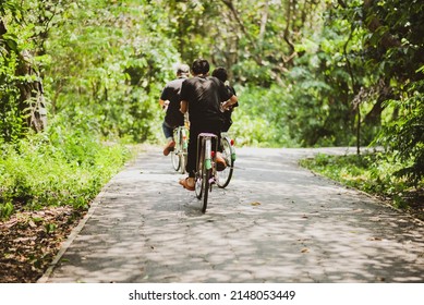 Teenager Boy Riding Bicycle  In The Park With Happy Family 