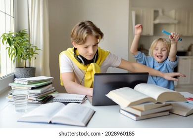 Teenager Boy Study At Home And His Younger Brother Screams And Interrupts Him. Online Education And Distance Learning For High School Students. School Boy Doing His Homework Using Gadgets.