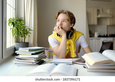 Teenager boy study at home. Online education and distance learning for children. School boy doing his physics homework using gadgets. Lectures and lessons on the internet for high school students