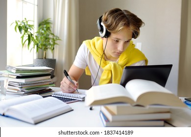 Teenager Boy Study At Home. Online Education And Distance Learning For Children. School Boy Doing His Physics Homework Using Gadgets. Lectures And Lessons On The Internet For High School Students