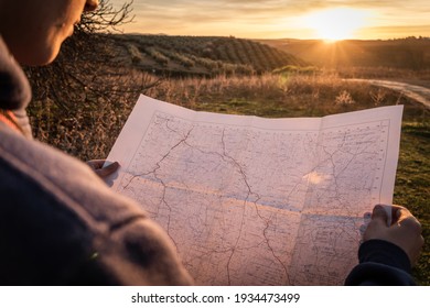 Teenager boy using map in the countryside and enjoying sunset. Selective focus. - Powered by Shutterstock