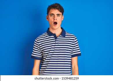 Teenager Boy Wearing Casual T-shirt Standing Over Blue Isolated Background In Shock Face, Looking Skeptical And Sarcastic, Surprised With Open Mouth