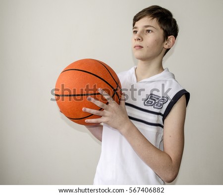 Similar – Teenage boy holding a basketball on a court