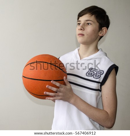 Similar – Teenage boy holding a basketball on a court