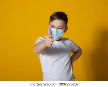 
Teenager boy in a white T-shirt on a yellow background with a medical mask on his face. Points to the mask. Quarantine, virus protection.Photography with different focal lengths. Focus on the face. - Shutterstock ID 2009293616