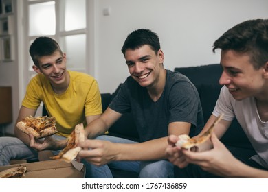 teenager boys eating pizza at home - Powered by Shutterstock