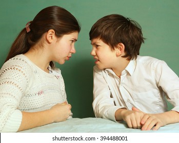 teenager brother and sister argue quarrel close up portrait on blue background