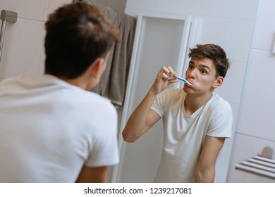 Teenager Brushing Teeth In Bathroom