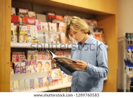 Teenager buying a magazin in a store