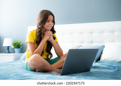 Teenager Child Girl Browsing Internet In A Laptop In The Bedroom At Home. Angry Teenager Girl, Upset And Unhappy Negative Emotion.