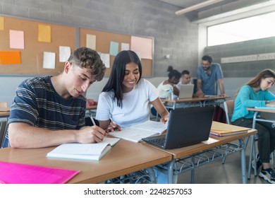 Teenager classmates doing exercise and working together in the Secondary School Classroom - Multi ethnic caucasian and Latin American students - Powered by Shutterstock