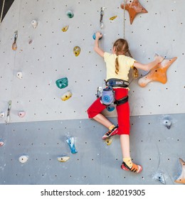 Teenager Climbing A Rock Wall