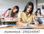 Teenager College Student girl writing notes in a Classroom , preparing University examination course 