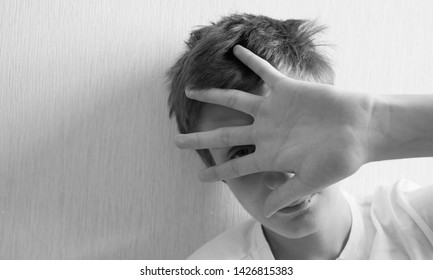 Teenager Covers His Face With His Hand