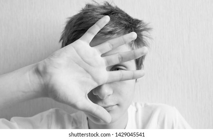 Teenager Covers His Face With His Hand