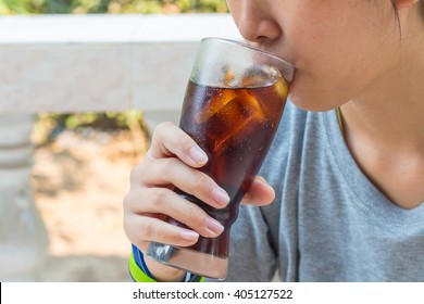 Teenager Drinking A Glass Of  Cold Fizzy Cola Drink