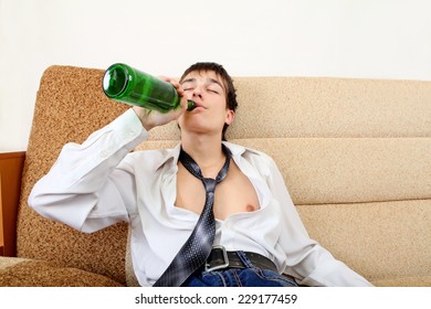 Teenager drinks a Beer on the Sofa at the Home