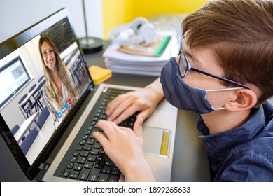 Teenager with face mask listening to her teacher on video call. Home schooling concept