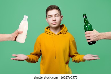 A teenager is faced with a choice of what to use - alcohol or milk. Hands holding out a bottle of alcohol and a bottle of milk - Shutterstock ID 1632760573