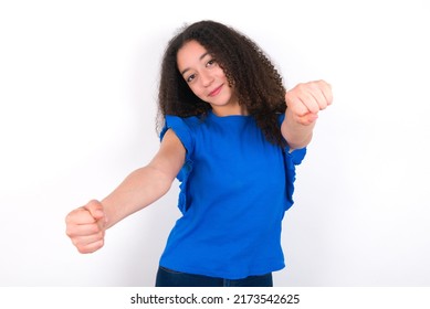 Teenager Girl With Afro Hair Style Wearing Blue T-shirt Over White Background  Imagine Steering Wheel Helm Rudder Passing Driving Exam Good Mood Fast Speed