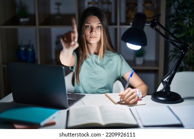 Teenager Girl Doing Homework At Home Late At Night Pointing With Finger Up And Angry Expression, Showing No Gesture 