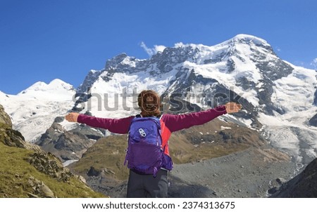 Teenager girl enjoying the panorama of Gorner Glacier and Monte Rosa summit in Switzerland, Zermatt area