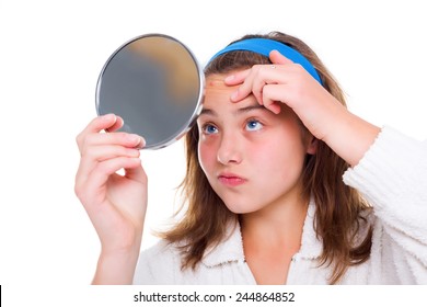 Teenager girl examine her pimples in the mirror