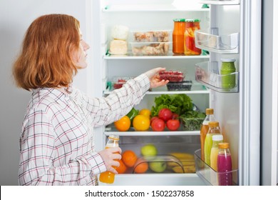 teenager girl at fridge with food - Shutterstock ID 1502237858