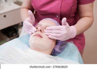 Teenager Girl Getting Facial Care By Beautician At Spa Salon, Side View, Close-up. Spa Beauty Treatment, Skincare. Getting Face Massage For Young Skin.