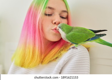 Teenager Girl Kissing A Parrot. Close-up Face Of Beautiful Young Woman And Green Quaker Parrot, Love Of The Owner And Pet Bird