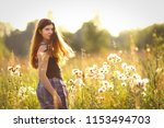 teenager girl with long brown hair in black tank top on summer sunset field horizontal photo