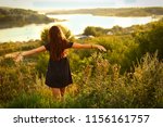 teenager girl with long brown hair in polka dot dress on summer river landscape background horizontal photo