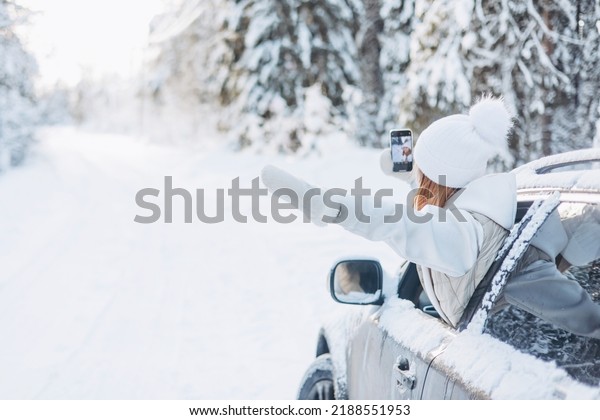 Teenager girl looking out of car window\
traveling in winter snowy forest. Road trip adventure and local\
travel concept. Happy child enjoying car ride. Christmas winter\
holidays and New year\
vacation