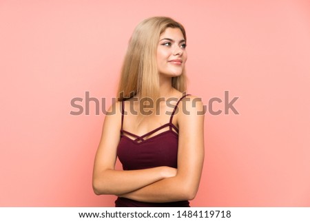 Teenager girl over isolated pink background looking to the side