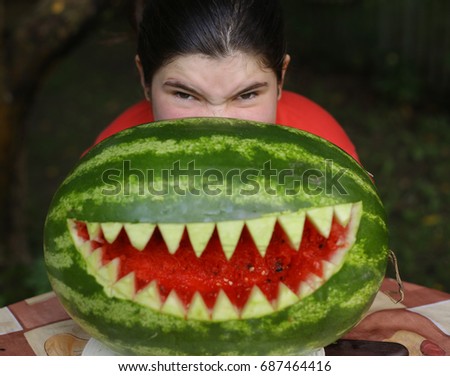 teenager girl perform moster with water melon cut sharp teeth mouth close up photo