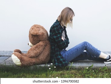 Teenager Girl Puberty Problems Concept, Sitting On The Ground With Toy Plush Bear. Angry Girl.