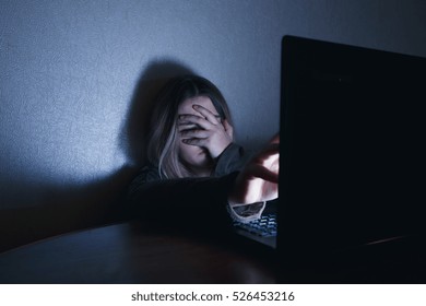 Teenager Girl Sitting In Front Of Computer Laptop Night, Abusing The Internet, The Victim Of The Harassment Of The Stalker Concept