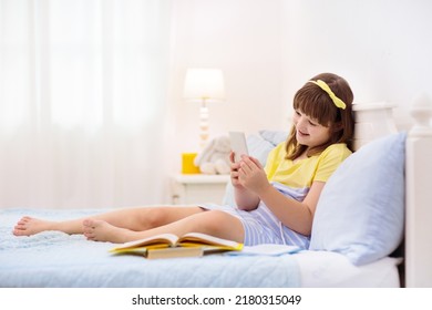 Teenager Girl With Smart Phone. Teen Kid Texting And Playing Online Game. School Child Sending Message On Social Media. Preteen Kid In White Bedroom Doing Homework For Remote Learning. Video Chat.