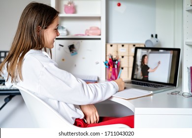 Teenager Girl Studying Online At Home Looking At Teacher Giving Lesson At Laptop Screen At  Quarantine Isolation Period. Home Schooling. Social Distancing. Online School Test.